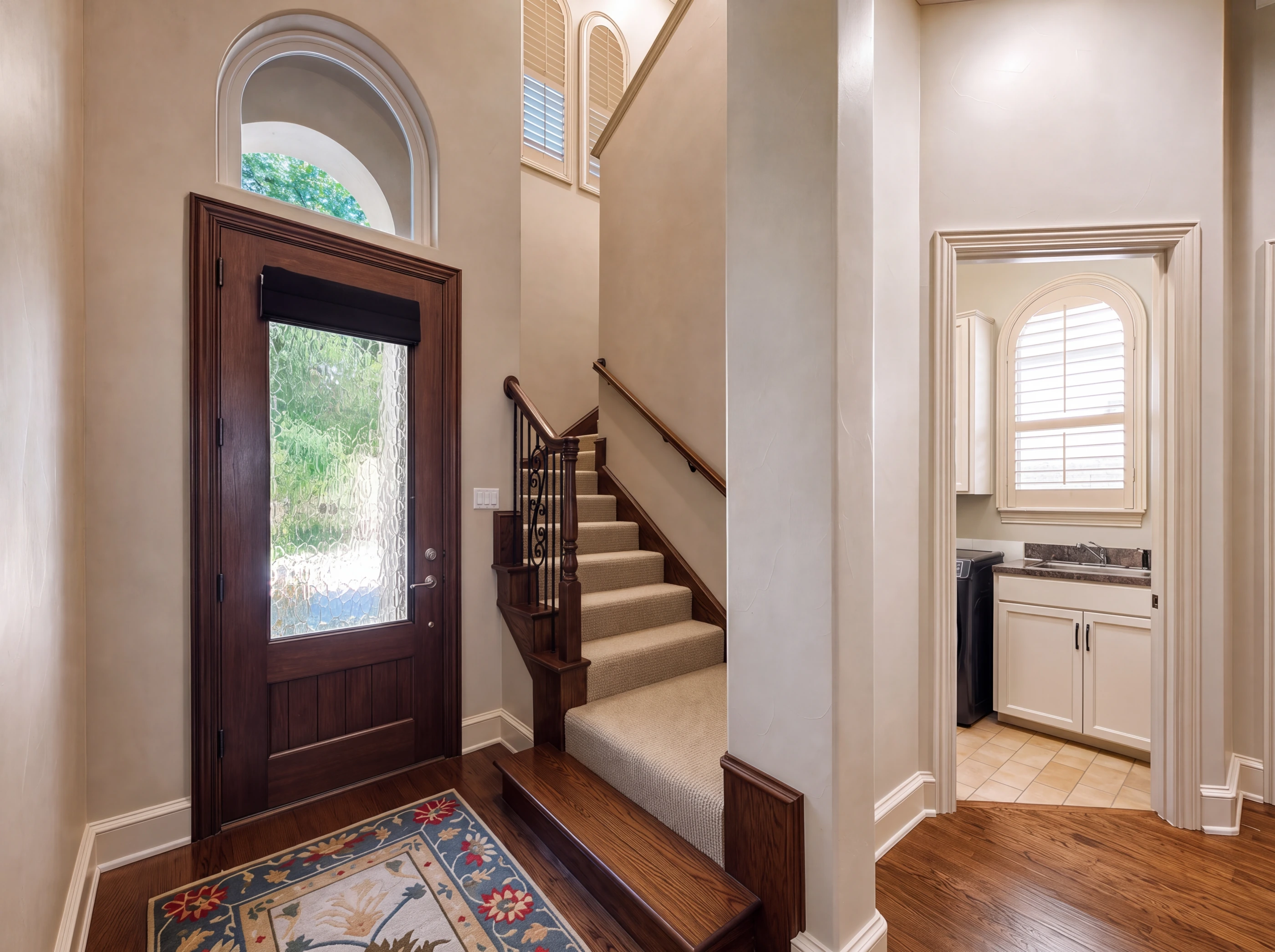 Entry at 4418 St Andrews with arched transom and wrought-iron staircase